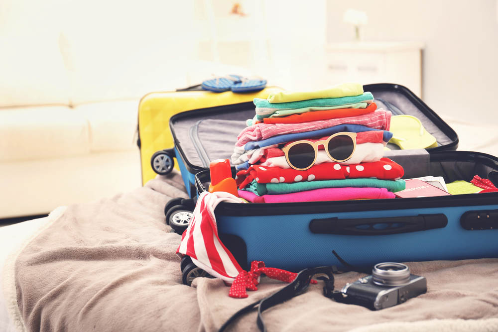 Foto de uma mala bem organizada com uma seção reservada para brinquedos
